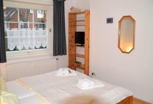um quarto com uma cama com toalhas em Haus 94- Whg 2 em Oldsum