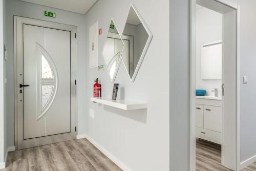 un corridoio bianco con porta e specchio di Casa Alan by Rent2u, Lda ad Arco da Calheta