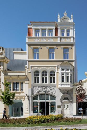 Großes weißes Gebäude mit Balkon in der Unterkunft Villa Theatro Heritage Apartments in Braga