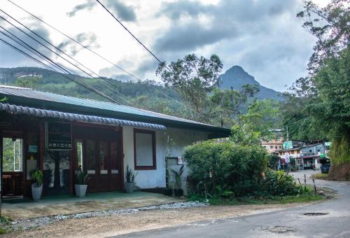 a building with a mountain in the background at Water Side Guest in Adams Peak