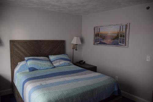 a bedroom with a bed and a picture on the wall at Rhea's Inn by the Sea in Middletown