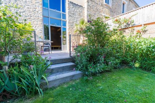 un jardin avec un escalier en bois menant à un bâtiment dans l'établissement Presbytère de Pancé, à Pancé