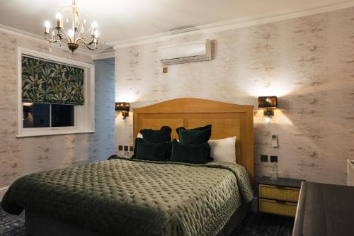 a bedroom with a bed and a window and a chandelier at The Spa Hotel in Royal Tunbridge Wells