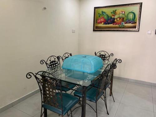 a glass table with chairs and a picture on the wall at Home in Nilai in Nilai