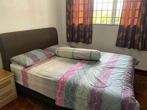 a bedroom with a bed with a comforter and a window at Home in Nilai in Nilai