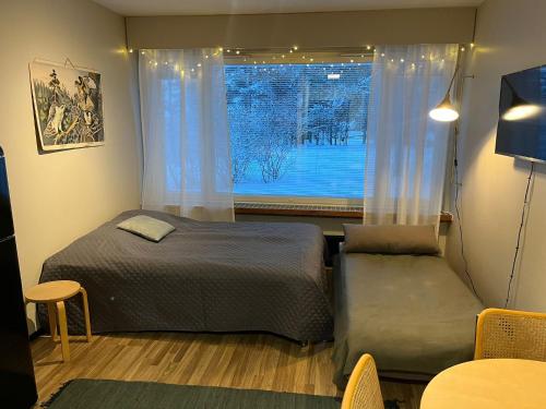 a bedroom with a bed and a window at Northern Lights Center Apartment 2 in Rovaniemi