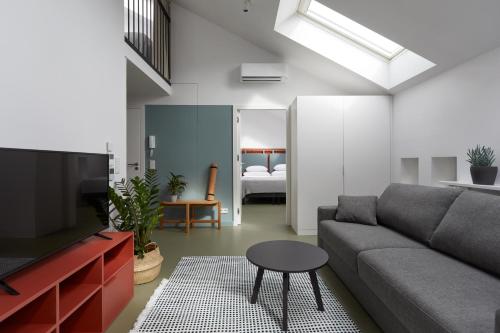a living room with a couch and a tv and a bedroom at PLANTONIA Aparthotel in Kraków