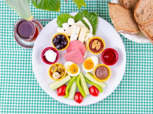 a plate of food with eggs and vegetables and bread at Family Istanbul Hotel in Istanbul