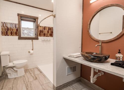 ein Badezimmer mit einem Waschbecken, einem WC und einem Spiegel in der Unterkunft The Harbor Hotel Chic, Retro Hotel in Prescott