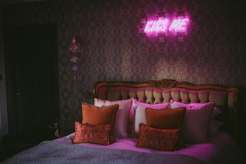 a bedroom with a bed with a neon sign above it at The Tempus at Charlton Hall Estate in Alnwick