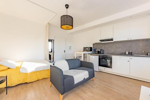 Cet appartement comprend une chambre avec un lit et un canapé ainsi qu'une cuisine. dans l'établissement Le studio Sicre proche commdités parking facile, à Castelsarrasin