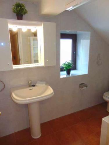 a bathroom with a sink and a mirror and a toilet at casa Panticosa Sunset WOWRURAL in Panticosa