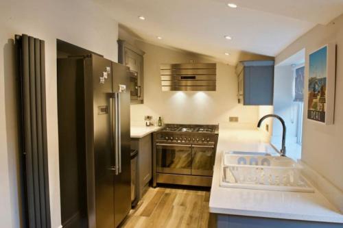 a kitchen with a stainless steel refrigerator and a stove at Malvern House in Deal