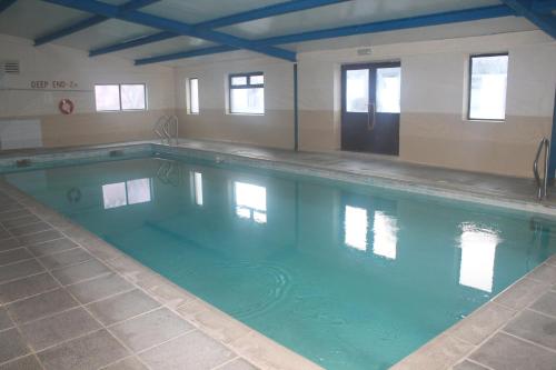 a swimming pool with blue water in a building at Riversdale Farm B&B in Ballinamore
