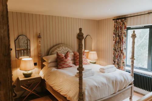 a bedroom with a bed and two lamps and a window at The Tempus at Charlton Hall Estate in Alnwick