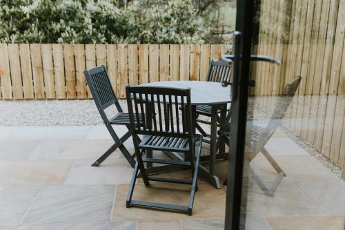 three chairs and a table in a patio at The Tempus at Charlton Hall Estate in Alnwick