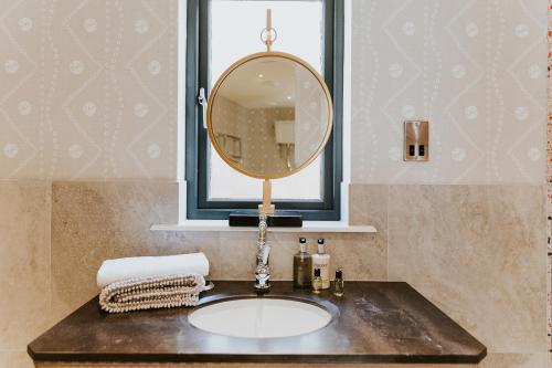 a bathroom sink with a mirror and a window at The Tempus at Charlton Hall Estate in Alnwick