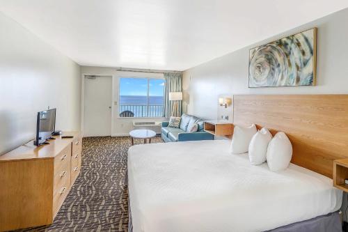 a hotel room with a large bed and a television at Beach Tower Beachfront Hotel, a By The Sea Resort in Panama City Beach
