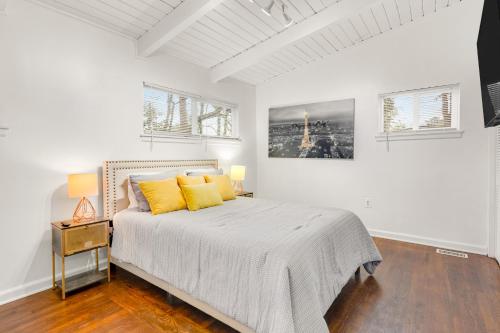 una camera da letto bianca con un letto con cuscini gialli di Drew Valley Villa ad Atlanta