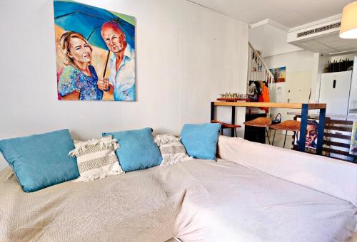 a large white bed with blue pillows on top of it at Oasis Beach in Altea