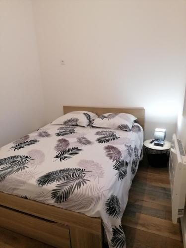 um quarto com uma cama com um edredão preto e branco em Chez Stephanie em Rang-du-Fliers