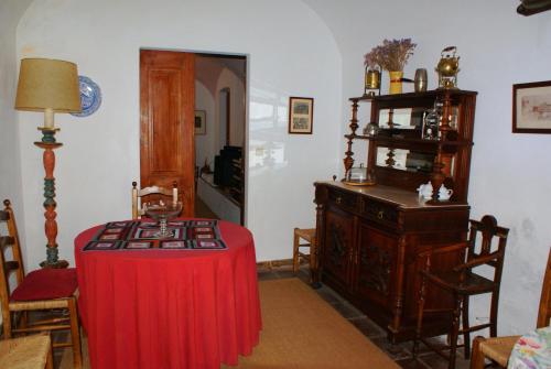 Zimmer mit einem Tisch und einem roten Tischtuch in der Unterkunft Casa da Muralha de Serpa in Serpa