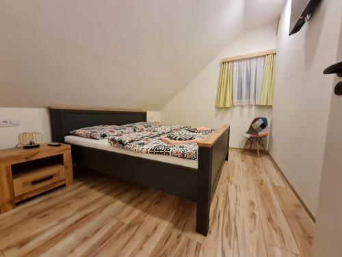 a bedroom with a bed and a wooden floor at Apartmán Konírna in Harrachov