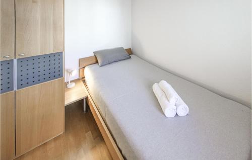 シェーンヴァルトにあるAmazing Apartment In Schnwald Im Schwarzwa With House A Mountain Viewの白いスリッパ2枚が備わる小さな部屋のベッド1台分です。