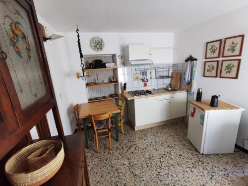 eine kleine Küche mit einem Tisch und einem Kühlschrank in der Unterkunft Interno X Pianissolo in Millesimo