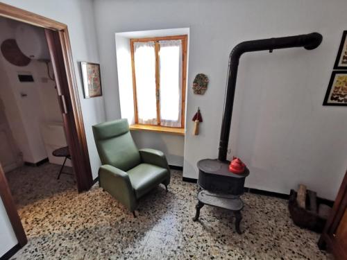 ein Wohnzimmer mit einem Stuhl und einem Herd in der Unterkunft Interno X Pianissolo in Millesimo