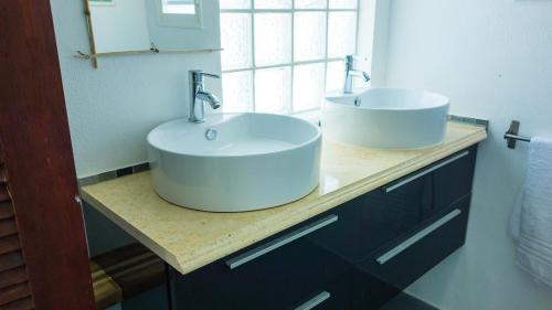 a bathroom with two sinks on a counter at PALM HOUSE in Oyster Pond