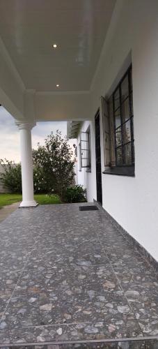 an empty porch of a white building with windows at Cheers in Evander