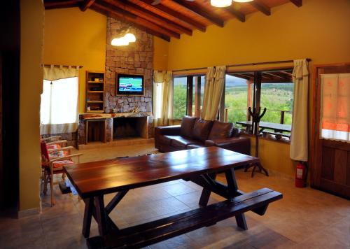 sala de estar con mesa de madera y sofá en Terrazas al Champaqui en Villa Yacanto