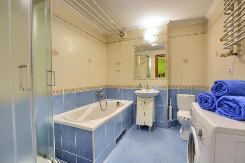 a bathroom with a tub and a toilet and a sink at Apartament przy Walowej in Łańcut