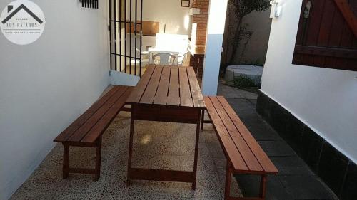 zwei Holzbänke neben einem Gebäude in der Unterkunft Posada Los Pájaros in Santa Rosa de Calamuchita
