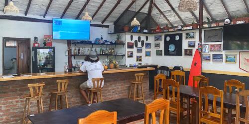 una persona sentada en un bar en un restaurante en Malevo Suites - Apartments, en Ayampe