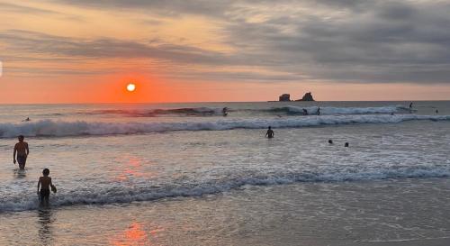 a group of people standing in the water at the beach at Las Golondrinas Ayampe in Ayampe