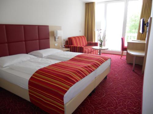 ein Hotelzimmer mit einem großen Bett und einem Wohnzimmer in der Unterkunft Werzers Seehotel Wallerwirt in Techelsberg am Worthersee