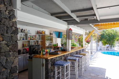 a bar with stools at a resort with a pool at HOTEL MOHITERO in Kamari