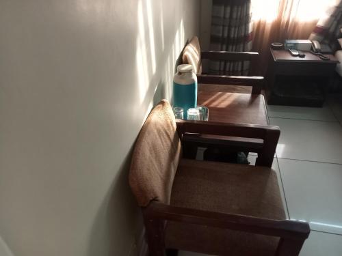 een tafel en stoel met een fles erop bij Hotel Bilal in Karachi