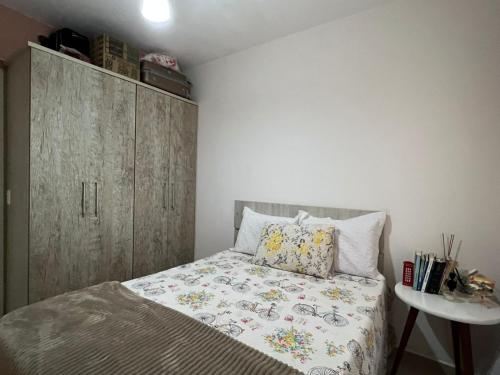 1 dormitorio con 1 cama y armario de madera en Apartamento 2 dorm. em Bombas SC, en Bombinhas