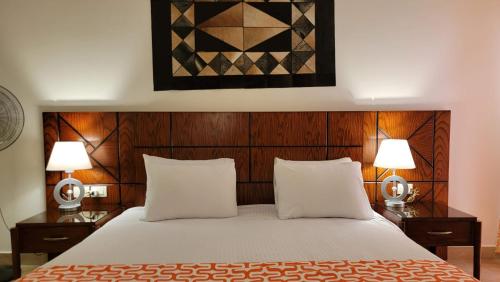 sypialnia z łóżkiem z 2 szafkami nocnymi i 2 lampami w obiekcie Oyster Bay Beach Resort - Luxury Serviced Condo w Marsa Alam