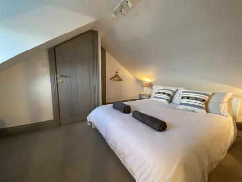 a bedroom with a large white bed with pillows at Mary's Cottage in Kingsdown