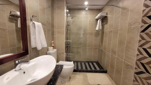 a bathroom with a sink and a toilet and a shower at Oyster Bay Beach Resort - Luxury Serviced Condo in Marsa Alam City