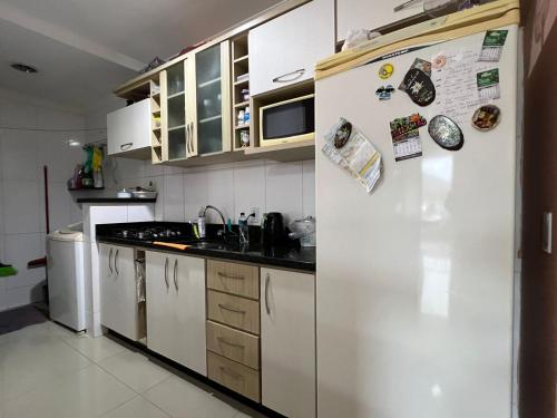 una cocina con una nevera blanca con imanes. en Apartamento 2 dorm. em Bombas SC, en Bombinhas