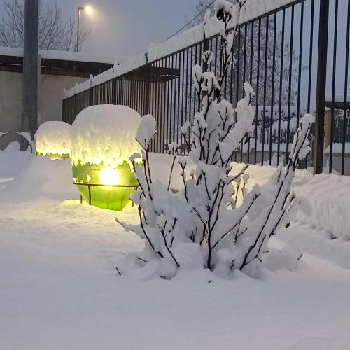 a fire hydrant covered in snow next to a fence at SANTINO'S HOUSE in Peveragno