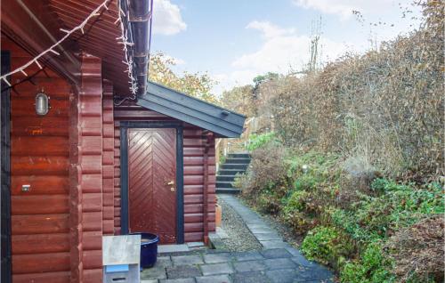 a wooden shed with a red door in a garden at Cozy Home In Diemelsee With Wifi in Diemelsee