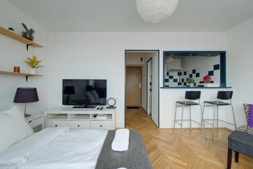 a bedroom with a bed and a desk with a tv at Noctis Old Town in Warsaw