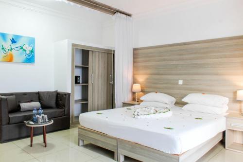 1 dormitorio con 1 cama grande y 1 sofá en Morning Star Diani, en Diani Beach