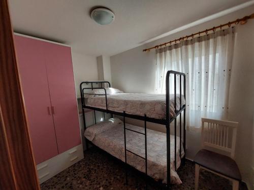 a bedroom with two bunk beds and a pink cabinet at Apartamento Bellavista in Daimuz